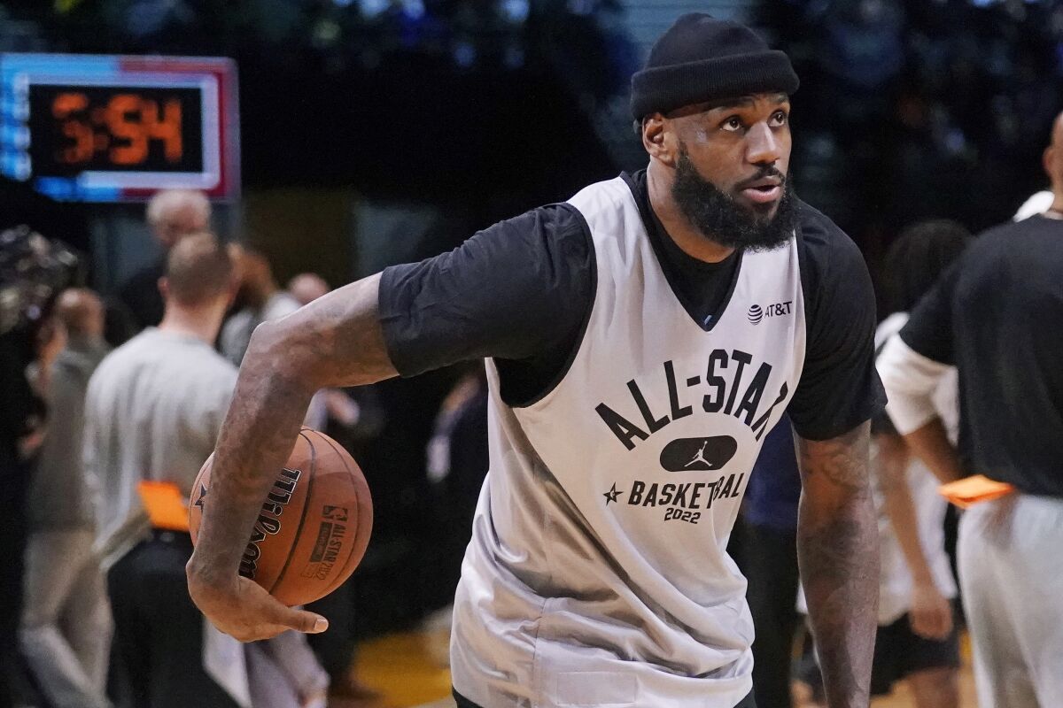 Lakers forward LeBron James grabs a basketball during a practice session for the NBA All-Star game.