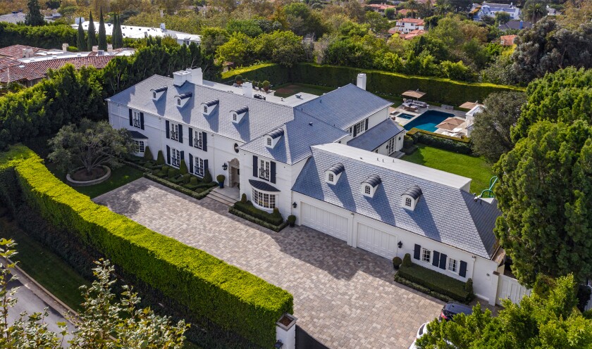 Secluded behind mature hedges, the traditional-style home includes a park-like backyard and a 2-bedroom guesthouse and studio