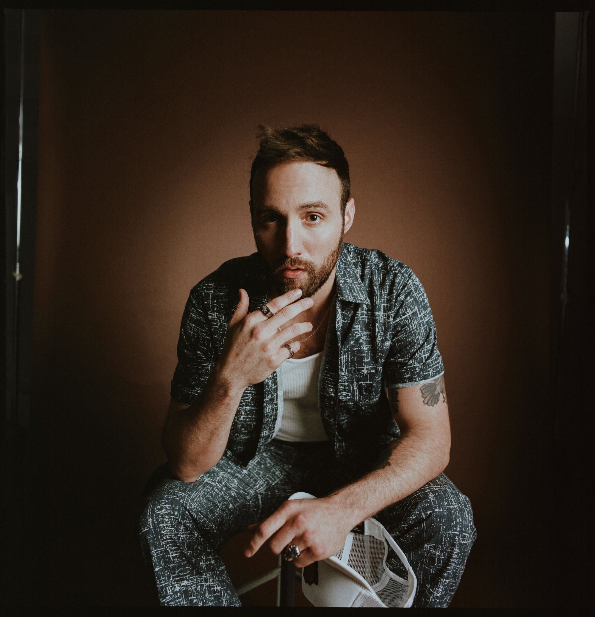 Male singer-songwriter sitting for a photo
