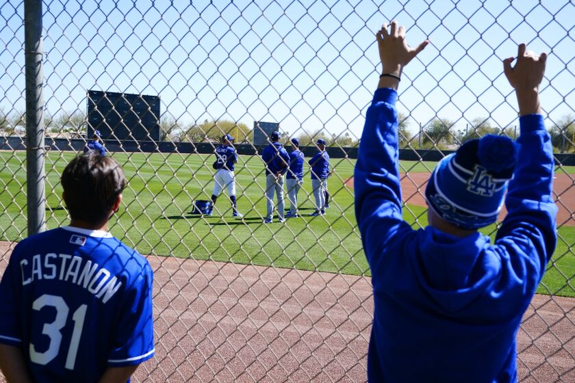 Los Angeles Dodgers fans watch players during a spring training baseball workout Sunday, March 13, 2022, in Phoenix. (AP Photo/Ross D. Franklin)