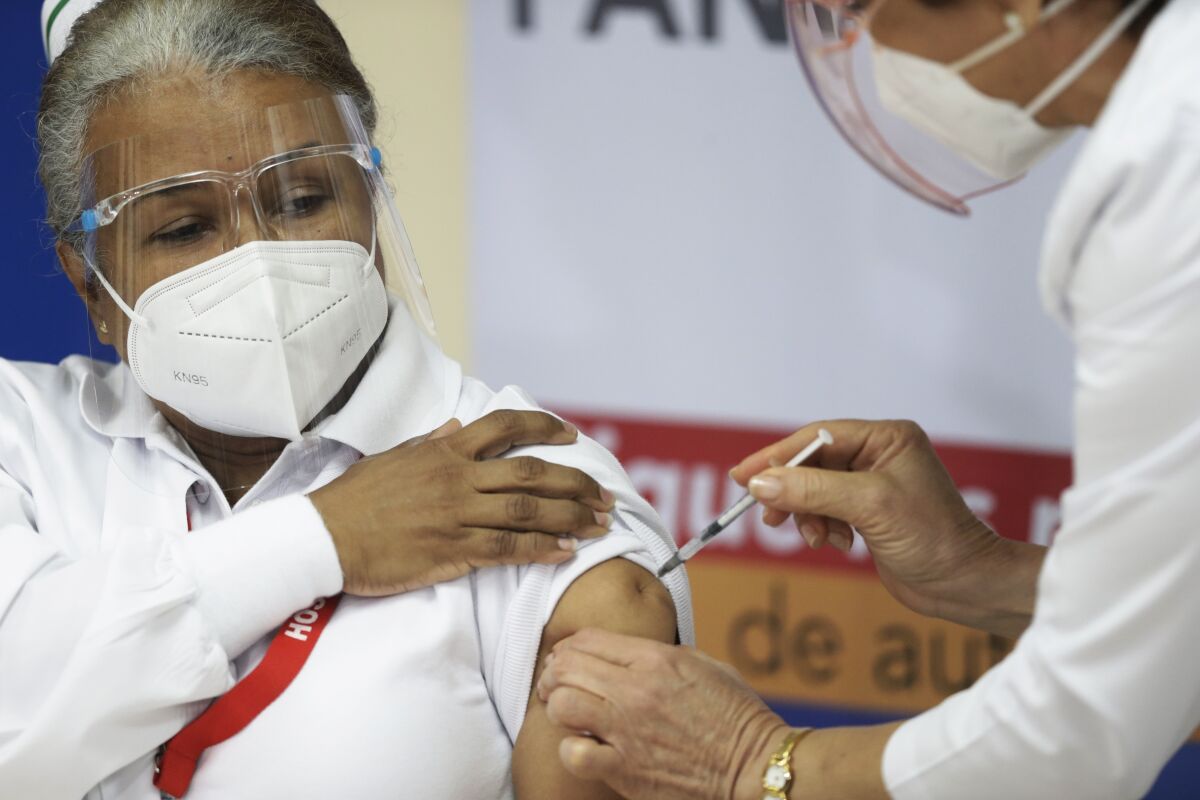 La enfermera Violeta Gaona, de 59 años, recibe una inyección de la vacuna Pfizer-BioNTech para COVID-19 