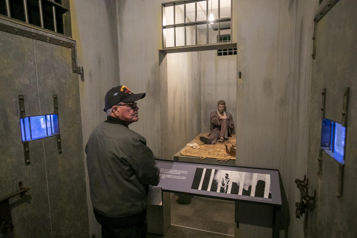 Richard Huerta, a Vietnam veteran, views a replica of a prison cell. 