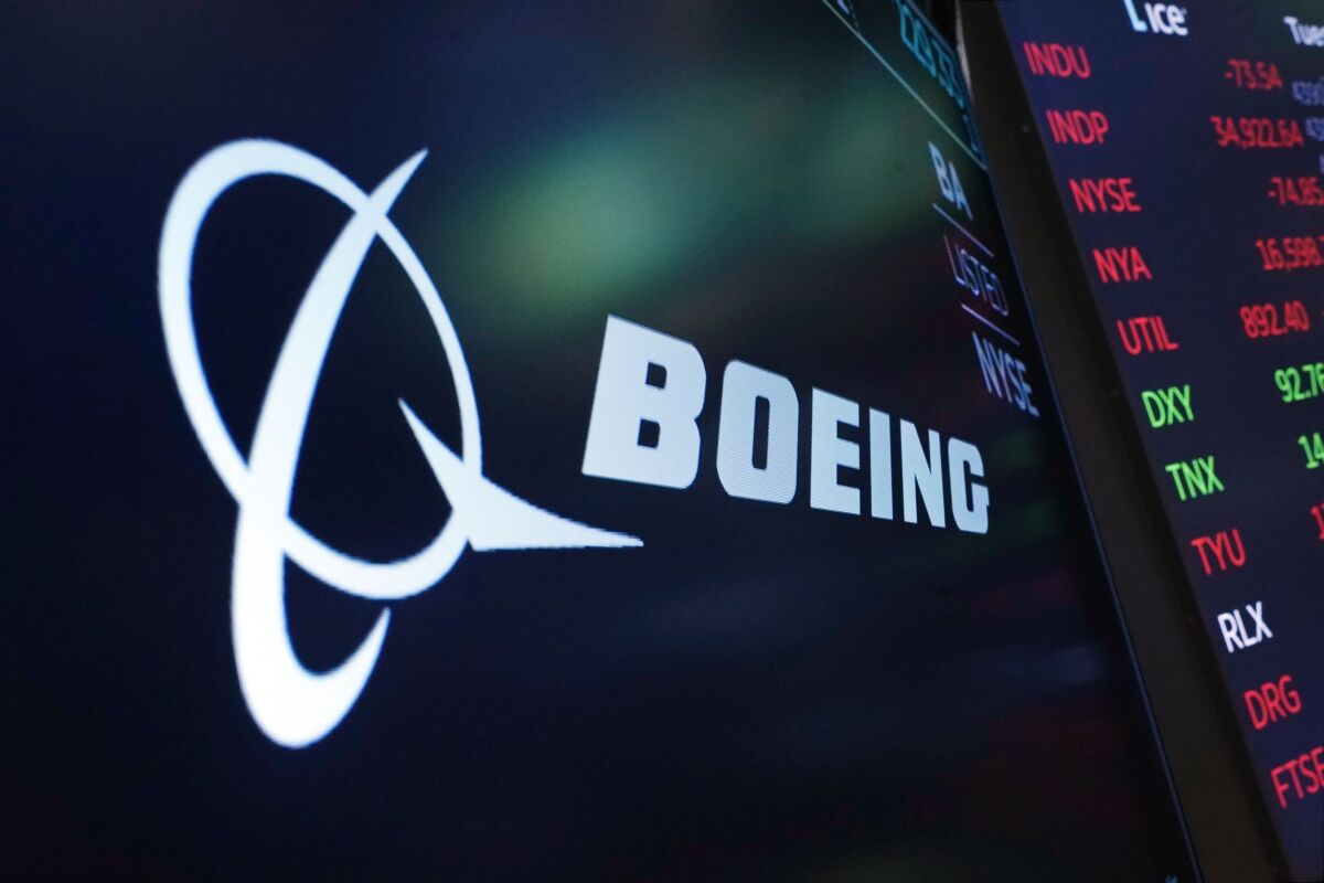 FILE - The logo for Boeing appears on a screen above a trading post on the floor of the New York Stock Exchange, Tuesday, July 13, 2021. Boeing is behind schedule in submitting documentation for new versions of its 737 Max jetliner, and it's asking Congress for more time. Federal officials say Boeing has completed little of the work necessary to certify the new Max versions by a Dec. 31, 2022 deadline. (AP Photo/Richard Drew, file)