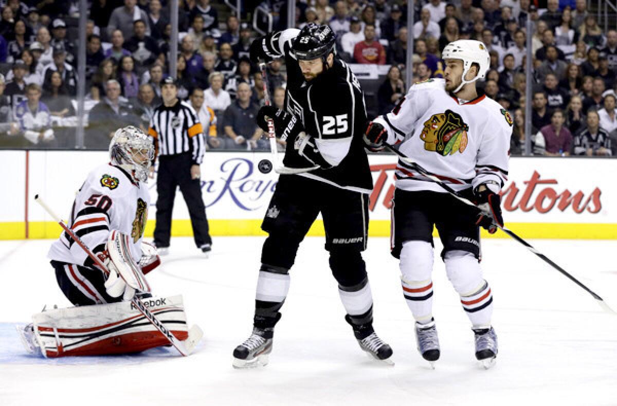 Kings winger Dustin Penner tries to redirect the puck between Blackhawks goalie Corey Crawford and defenseman Niklas Hjalmarsson in the first period of Game 4 on Thursday night at Staples Center.