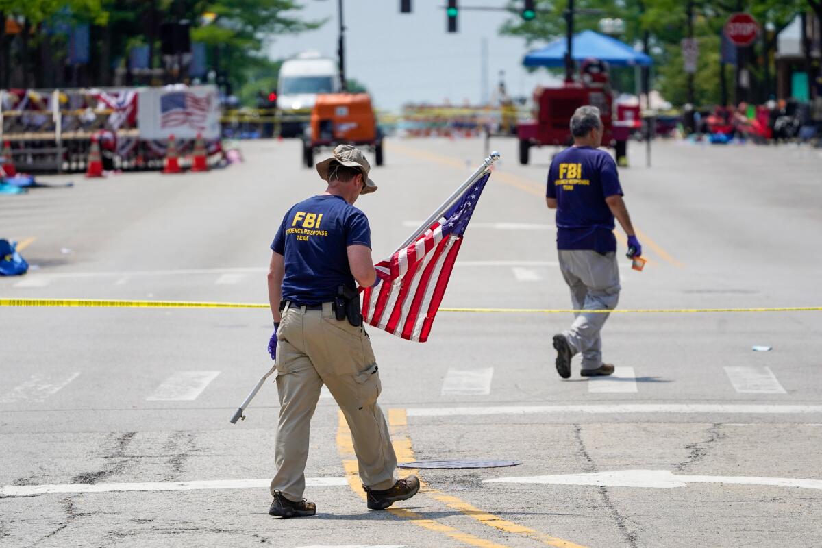 An FBI worker carries an American flag