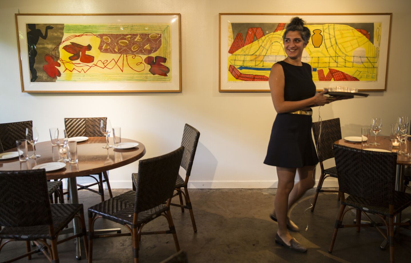 Hostess Shagha Arianna preps the dining room at Michael's in Santa Monica.