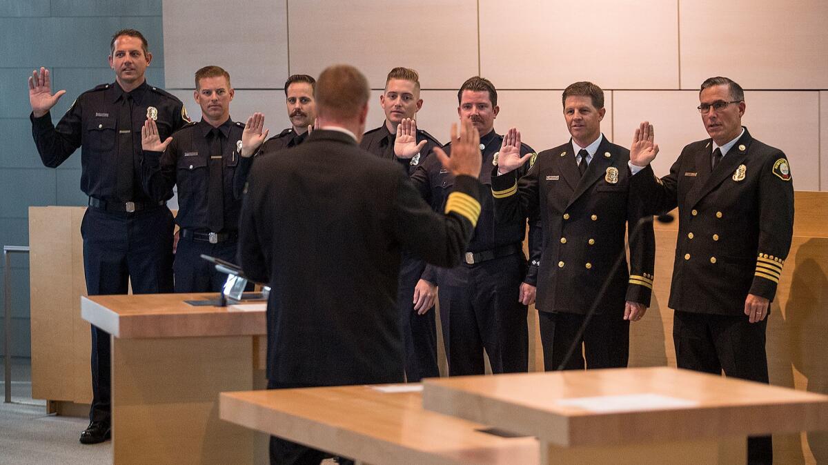 Newport Beach Fire Department personnel, from left, Matt Ambrose, Matt Skelly, John Mollica, Anthony Terzo, Matthew Reis, Assistant Chief Jeff Boyles and Chief Chip Duncan take the oath of office during a promotion ceremony Tuesday. Nic Lucas is not pictured.
