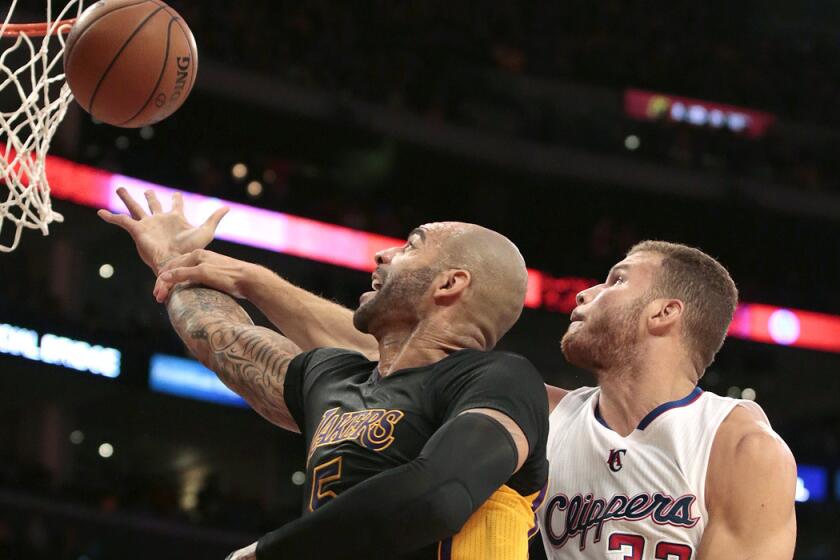 Lakers power forward Carlos Boozer is fouled by Clippers power forward Blake Griffin while attempting a layup in the during their game on Oct. 31.