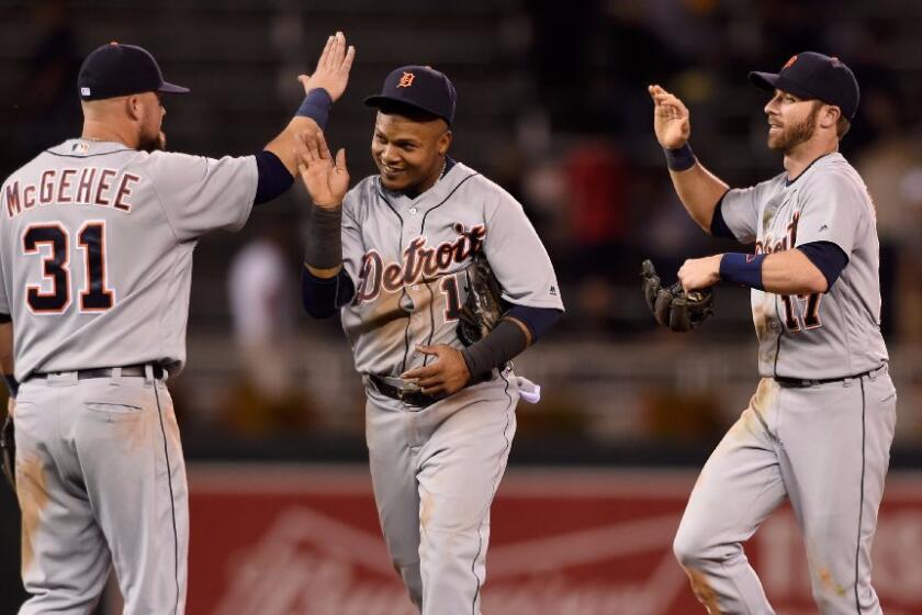 Casey McGehee (31), Erick Aybar (15) and Andrew Romine (17) of the Tigers celebrate a victory over the Twins on Aug. 24.