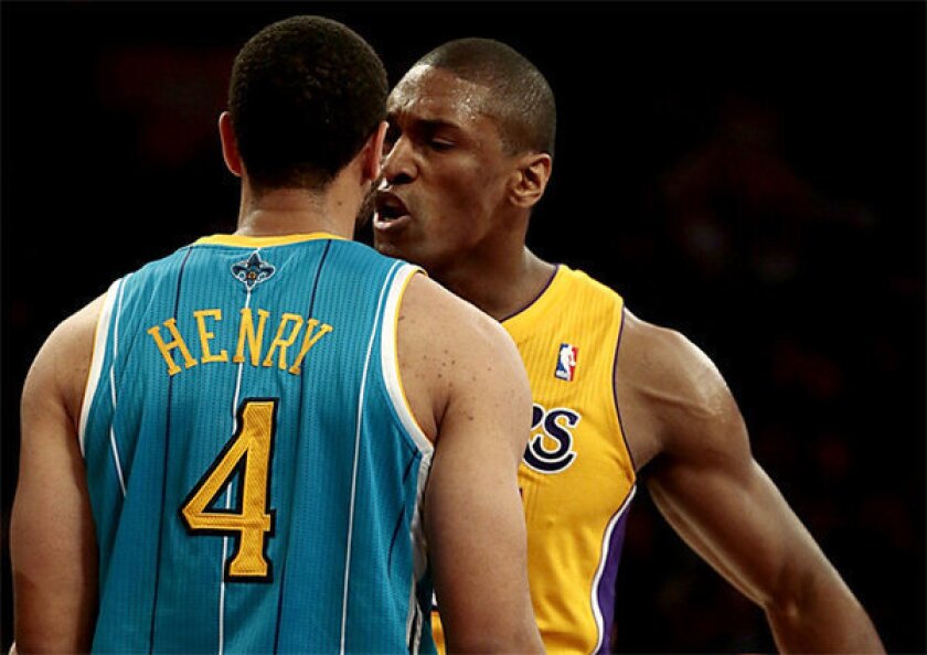 Lakers forward Metta World Peace jaws with New Orleans guard Xavier Henry.