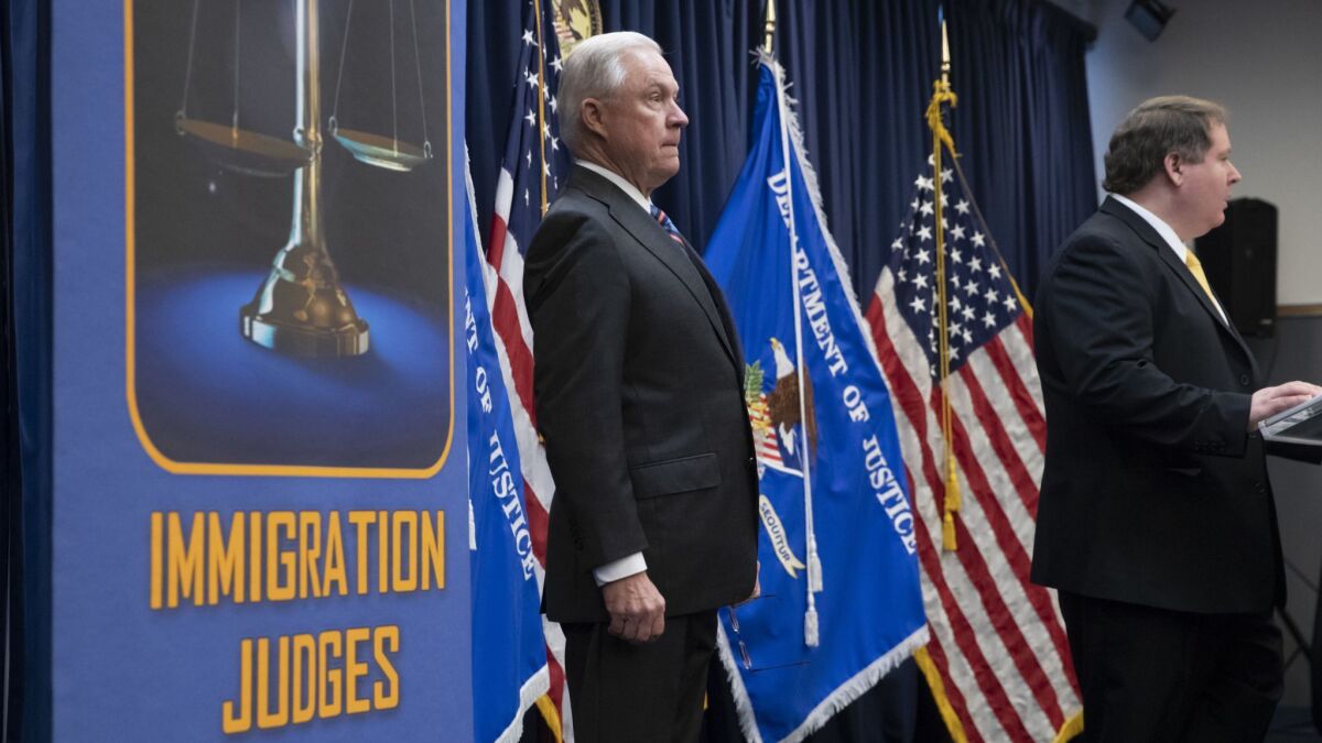 Attorney General Jeff Sessions is introduced by James McHenry, right, director of the Executive Office for Immigration Review, before addressing new immigration judges. Immigration judges work for the Justice Department and are not part of the Judicial branch of government.