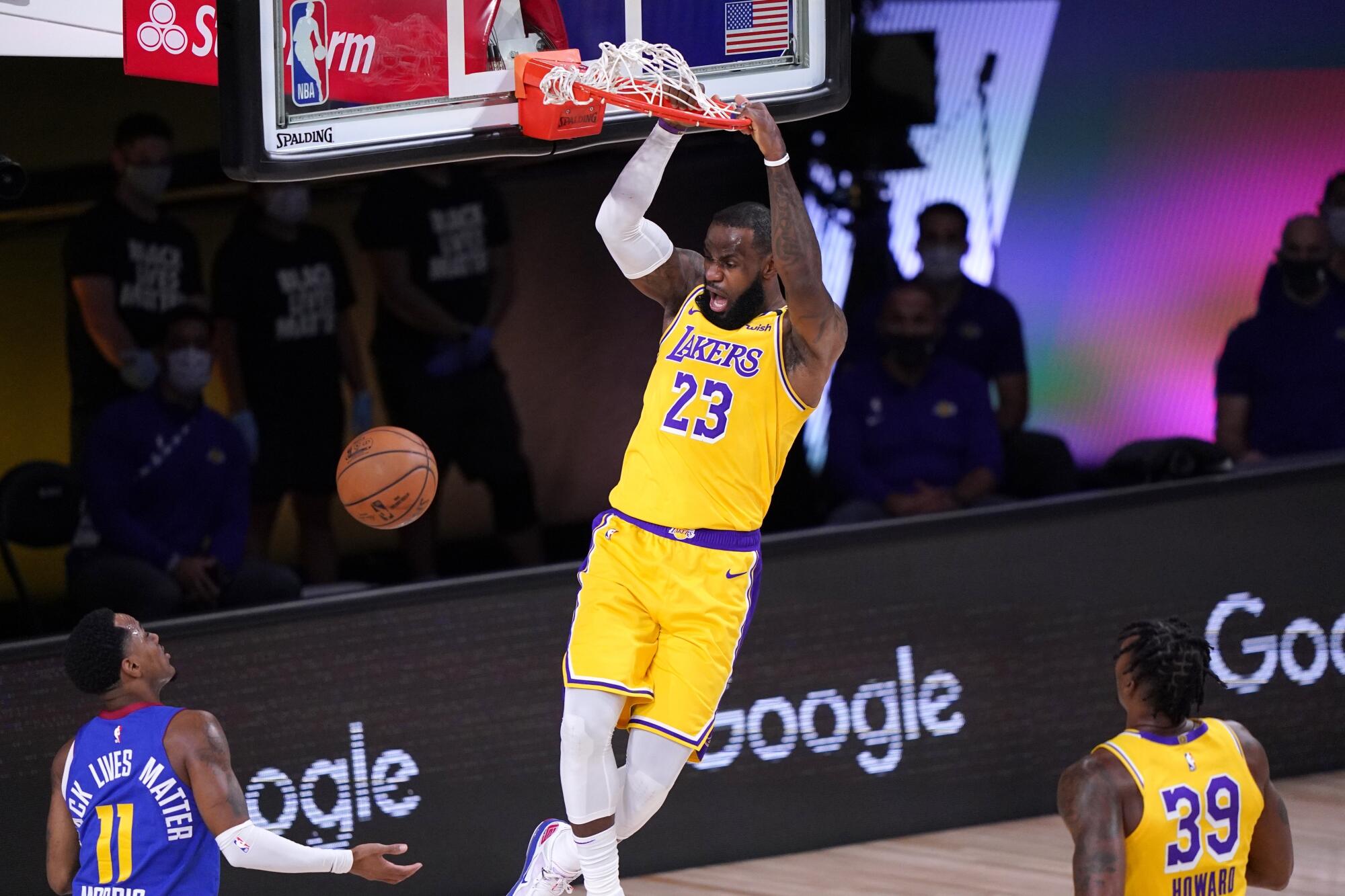Lakers star LeBron James dunks during the first half against the Denver Nuggets.