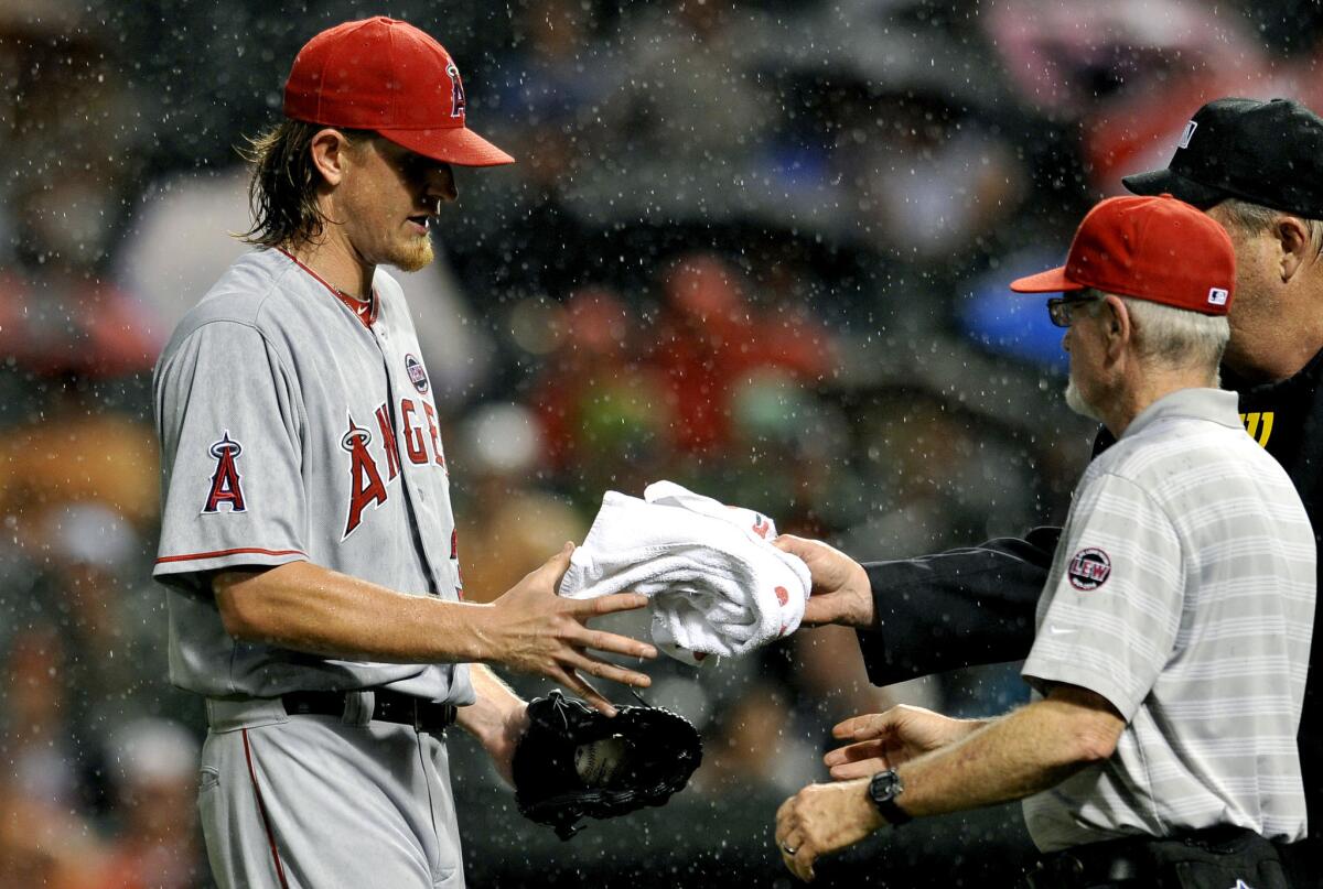 Angels pitcher Jered Weaver requests a towel as rain falls in the fourth inning of Monday's game against the Baltimore Orioles.