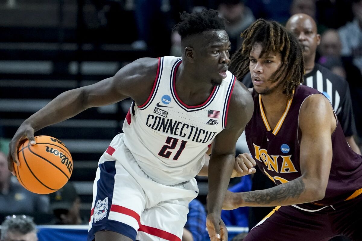 Connecticut's Adama Sanogo (21) drives against Iona's Silas Sunday (33) in the second half of a first-round college basketball game in the NCAA Tournament, Friday, March 17, 2023, in Albany, N.Y. (AP Photo/John Minchillo)