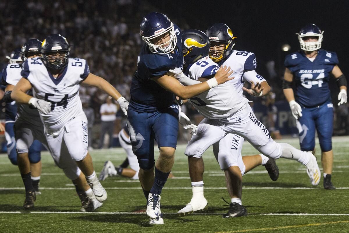 Newport Harbor quarterback Cole Lavin runs for a short gain against Santa Monica in a nonleague game on Friday at Davidson Field.