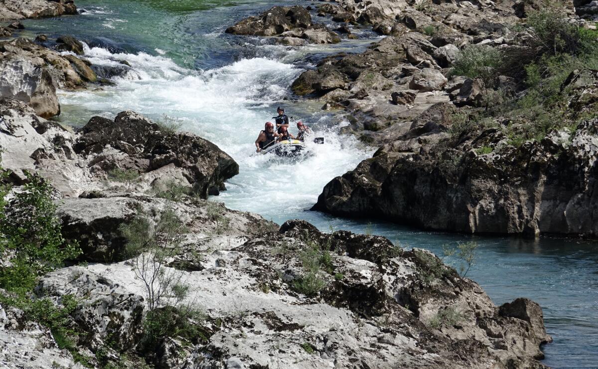 People rafting in a small rubber boat along the Neretva river near the town of Konjic, Bosnia, Saturday, July 2, 2022. It took a decade of court battles and street protests, but Balkan activists fighting to protect some of Europe's last wild rivers have scored an important conservation victory in Bosnia. A new electricity law, which passed Thursday, bans the further construction of small hydroelectric power plants in the larger of Bosnia's two independent entities. (AP Photo/Eldar Emric)