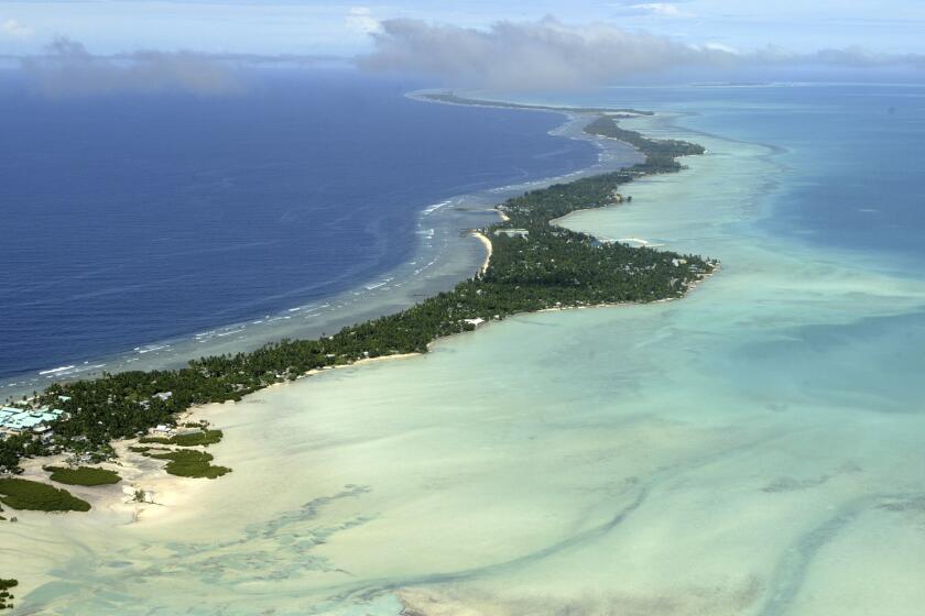 FILE - In this March 30, 2004, file photo, Tarawa atoll, Kiribati, is seen in an aerial view. Kiribati and several other small Pacific nations were among the last on the planet to have avoided any virus outbreaks, thanks to their remote locations and strict border controls. But their defenses appear no match against the highly contagious omicron variant. (AP Photo/Richard Vogel, File)