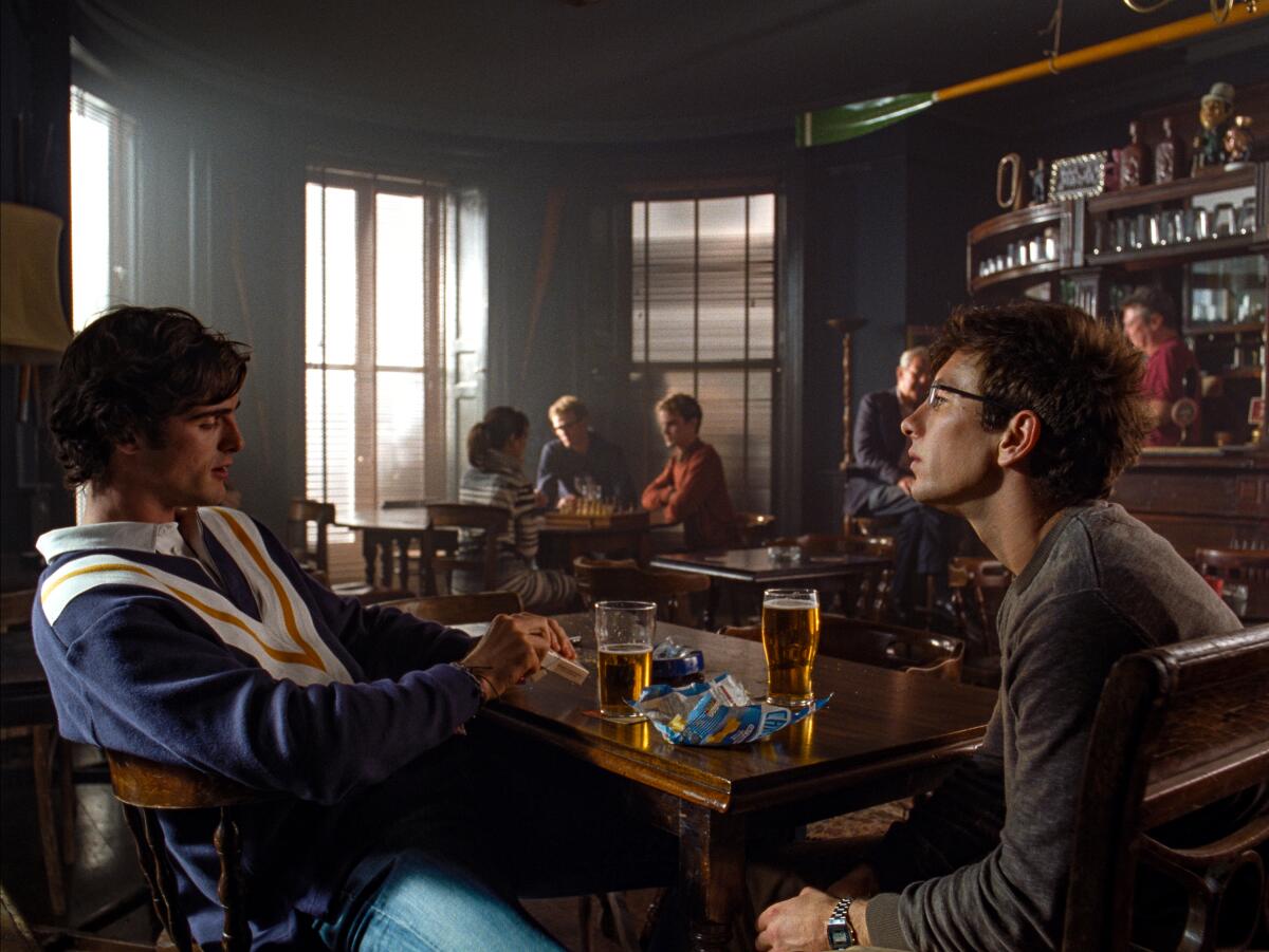 Two college students have beers in a pub.