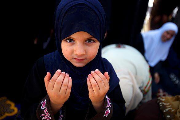 A Palestinian Muslim girl holds her hands in a praying position during the first Friday prayers of the holy fasting month of Ramadan at Al Aqsa mosque in Jerusalem's Old City.
