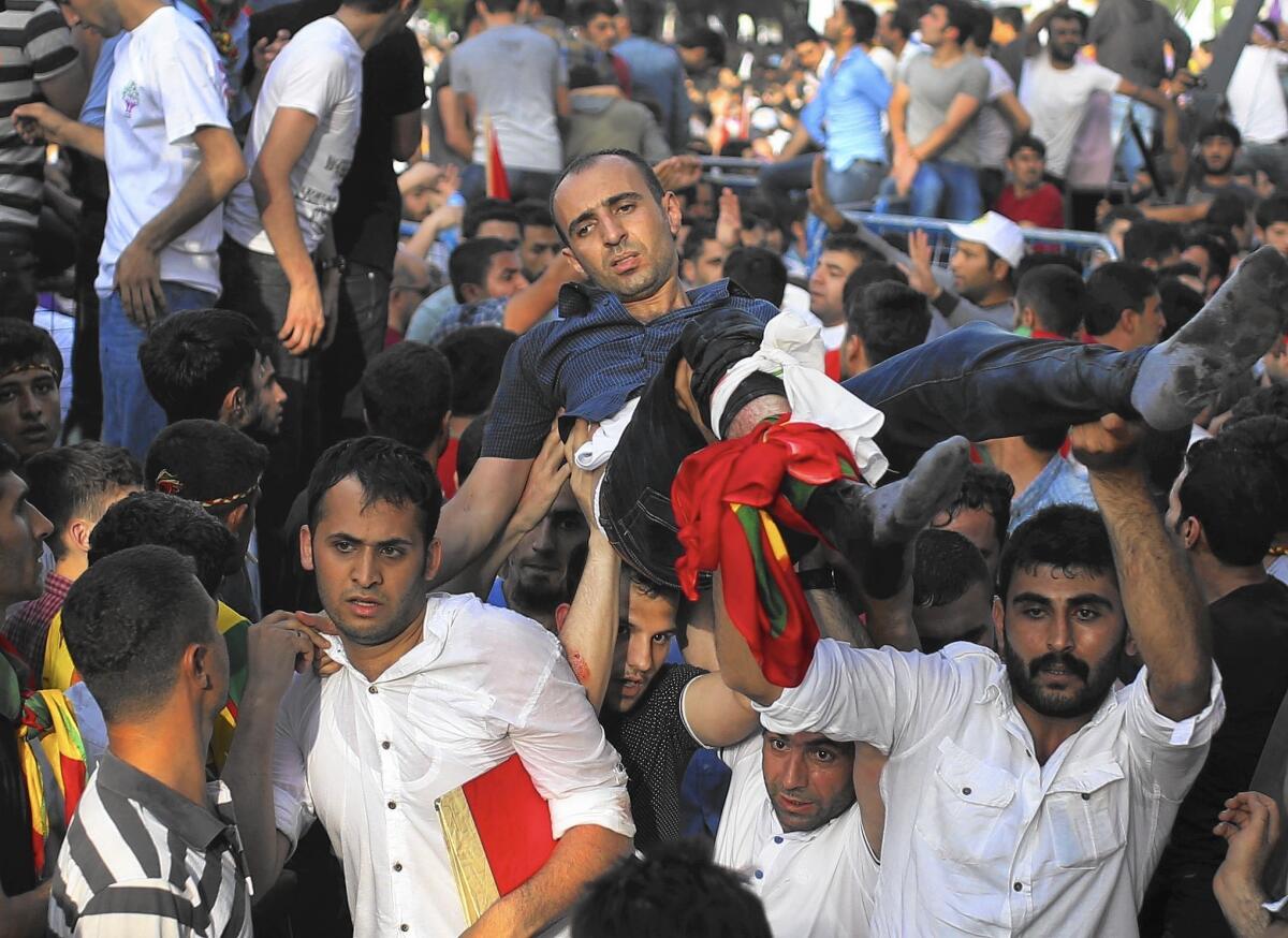 A wounded man is carried away after an explosion at a rally for the pro-Kurdish People’s Democratic Party, in Diyarbakir, southeastern Turkey, on June 5, 2015.