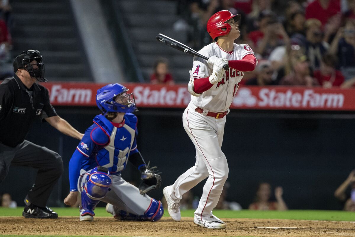 Angels' Shohei Ohtani flies out next to Texas Rangers catcher Jonah Heim.