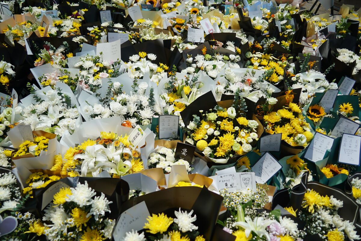 In this July 27, 2021, file photo, bouquets of flowers are placed outside the entrance to a subway station in Zhengzhou in central China's Henan Province, where numerous people died after a record-breaking downpour flooded the area. Chinese authorities have announced a huge jump in the death toll from recent floods. The Henan province government said Monday, Aug. 1, 2021, that over 300 people died and at least 50 remain missing. (AP Photo/Dake Kang, File)