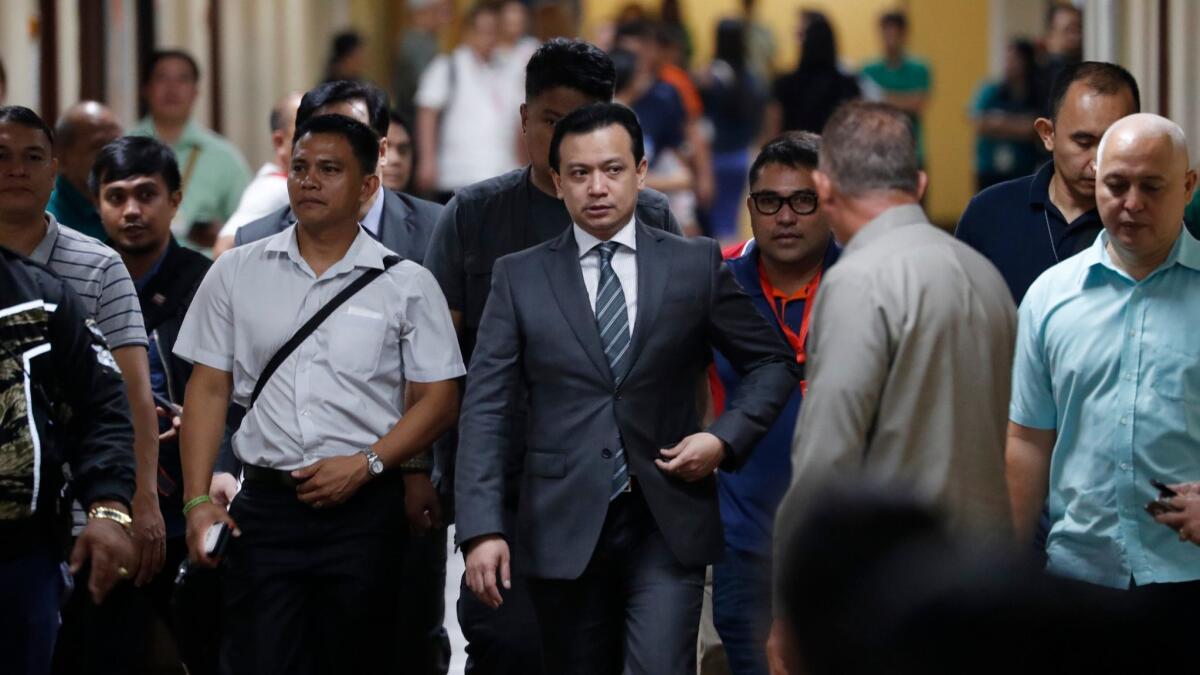 Philippine Sen. Antonio Trillanes IV, center, returns to the Senate building to hold a news conference after posting bail in Pasay, south of Manila, Tuesday.
