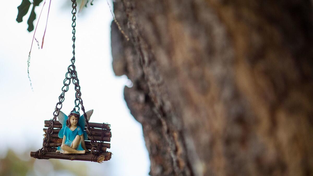 A fairy rests on a handmade swing.