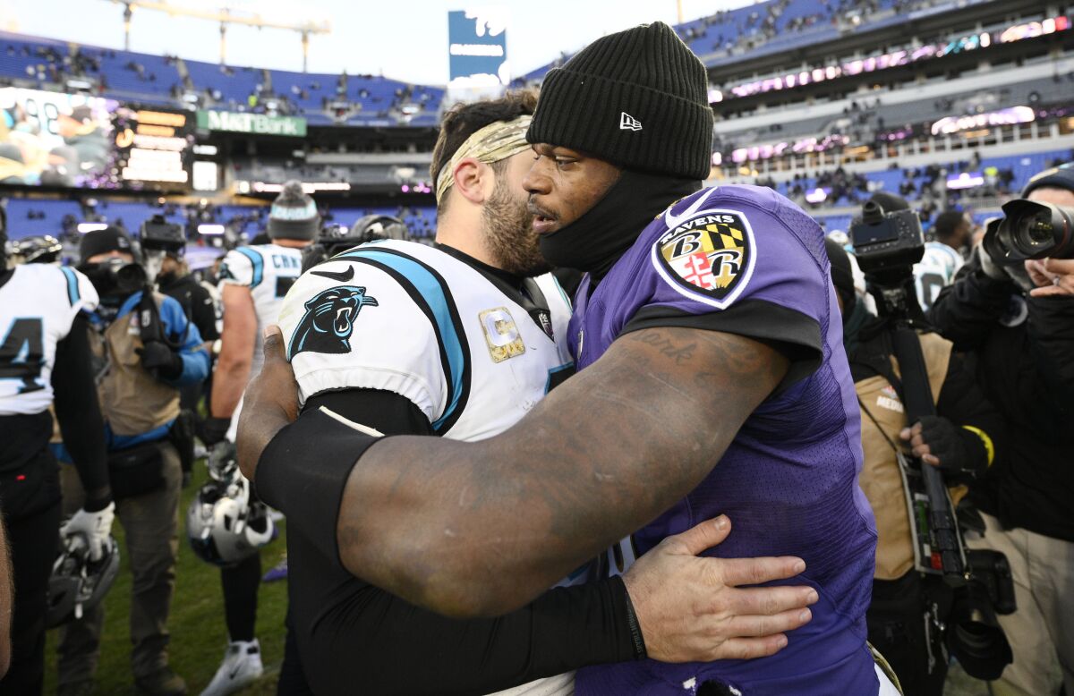 Baltimore Ravens quarterback Lamar Jackson, right, hugs Carolina Panthers quarterback Baker Mayfield, left, after an NFL football game Sunday, Nov. 20, 2022, in Baltimore. (AP Photo/Nick Wass)