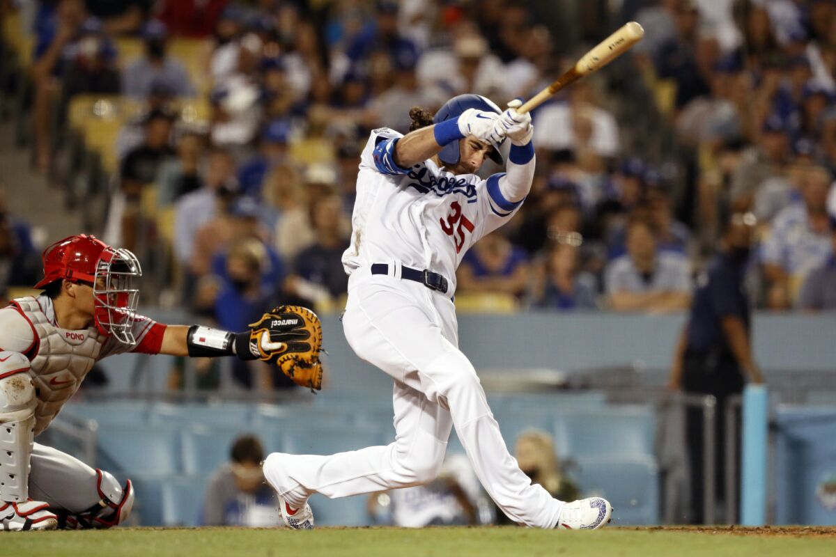 The Dodgers' Cody Bellinger connects for a homer Aug. 7, 2021. Angels catcher Kurt Suzuki is at left.