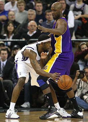 John Salmons, left, passes the ball behind Lamar Odom of the Lakers Tuesday night. Salmons scored 21 points to help the Kings defeat the Lakers in Sacramento.