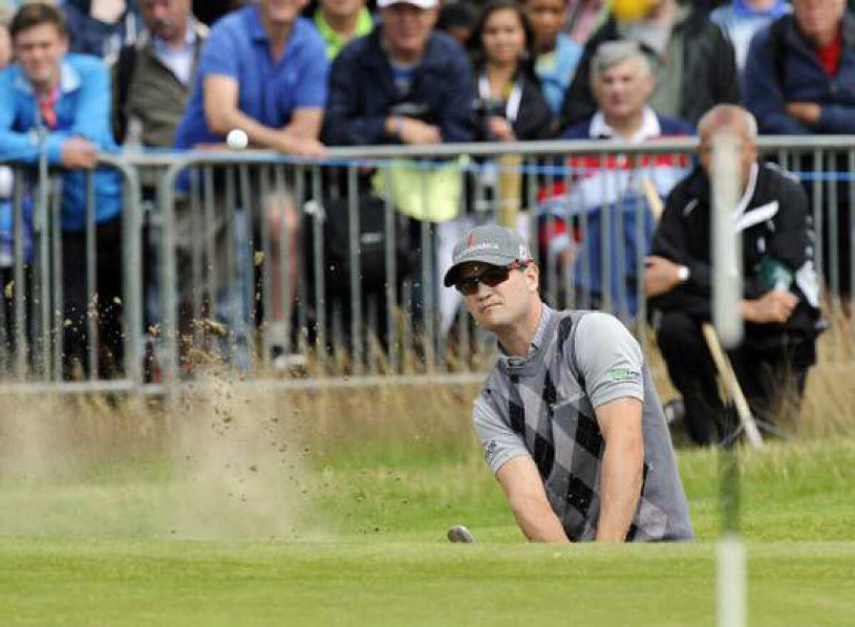 Zach Johnson plays out of a bunker on the first day of The British Open.