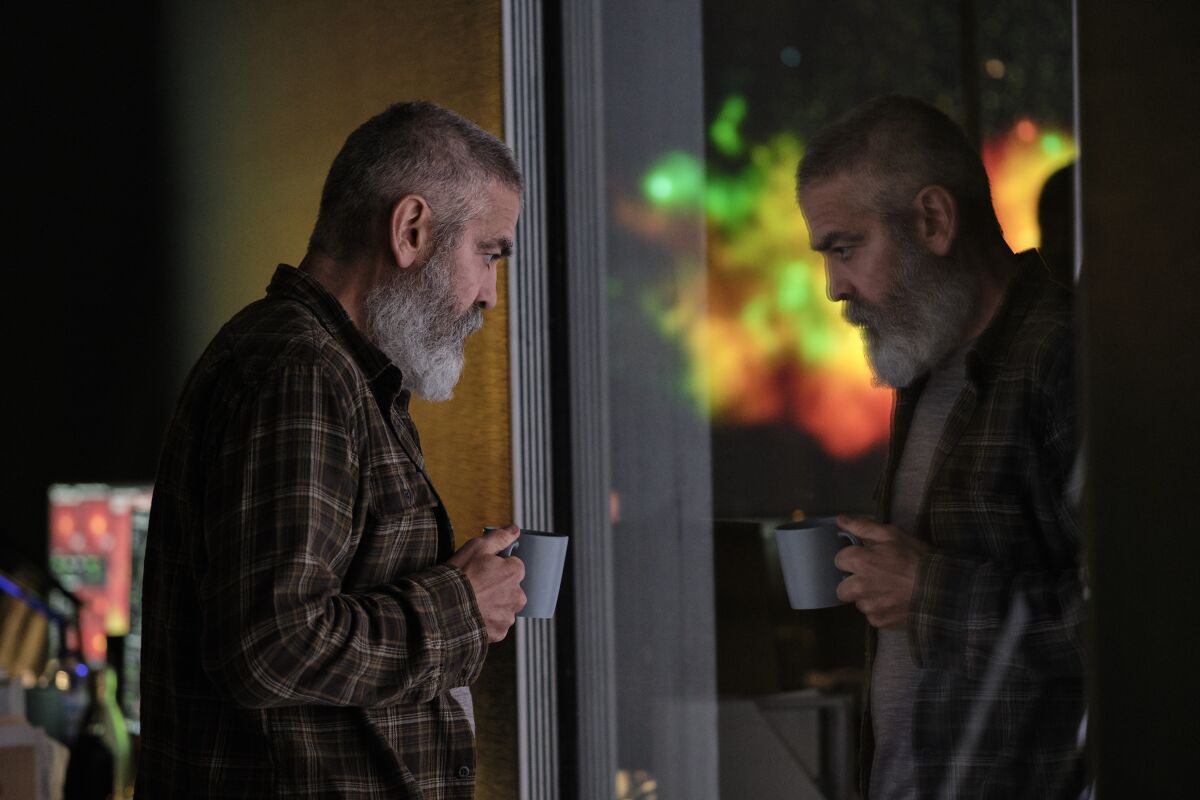 George Clooney as Augustine Lofthouse looks at his reflection in a window in "The Midnight Sky"