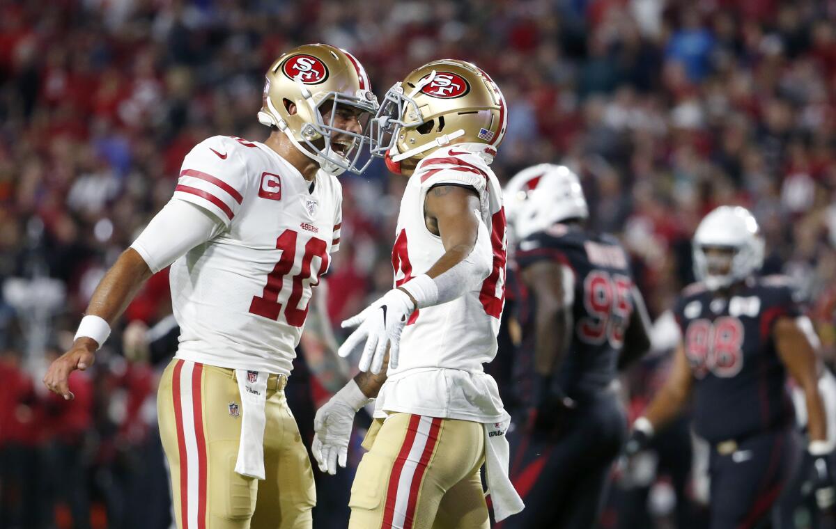 San Francisco 49ers quarterback Jimmy Garoppolo (10) celebrates with receiver Kendrick Bourne (84) after Bourne's touchdown catch against the Arizona Cardinals during the first half on Thursday in Glendale, Ariz.
