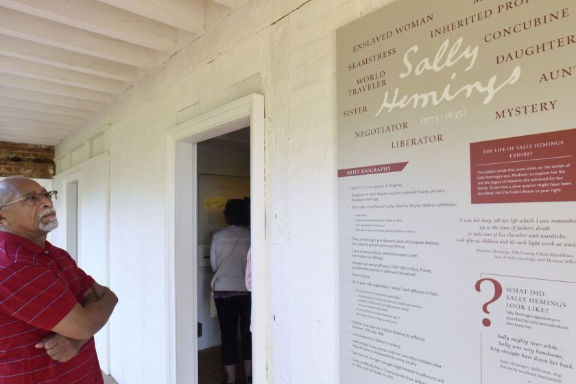 In this photo provided by The Thomas Jefferson Foundation, Bernard Hairston, of Charlottesville, Va., reads a plaque about Sally Hemings during the opening of the South Wing at Monticello, Thomas Jefferson's estate in Charlottesville, Va., on Saturday, June 16, 2018. Sally Hemings was an enslaved woman who was the mother of six of Jefferson's children. (Steve Ruark/The Thomas Jefferson Foundation via AP)