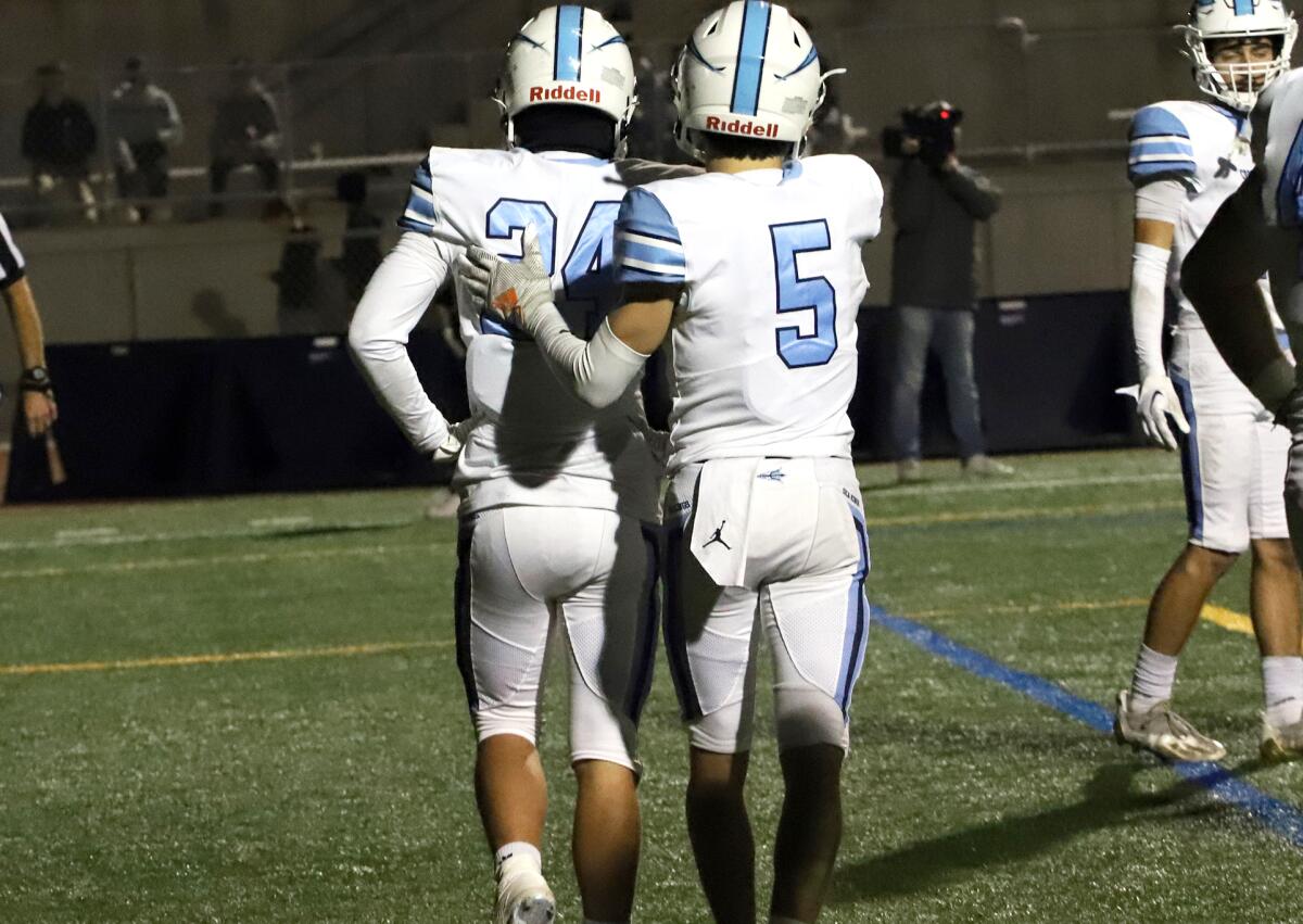 Corona del Mar's Aiden Walsh (24) and Oliver Ayala (5) walk off the field after a Yorba Linda touchdown. 