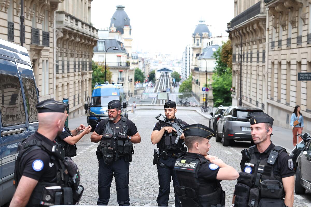 Police officers talk to each other on a street in Paris before the start of the Summer Games.