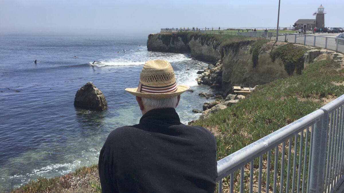 Steve Lopez watches surfers ride waves at Steamer's Lane, Santa Cruz.