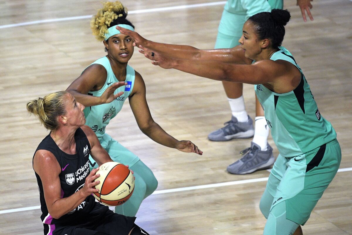 Chicago Sky guard Courtney Vandersloot, left, drives to the basket in front of New York Liberty center Kiah Stokes, right, and guard Paris Kea during the second half of a WNBA basketball game, Tuesday, Aug. 25, 2020, in Bradenton, Fla. (AP Photo/Phelan M. Ebenhack)