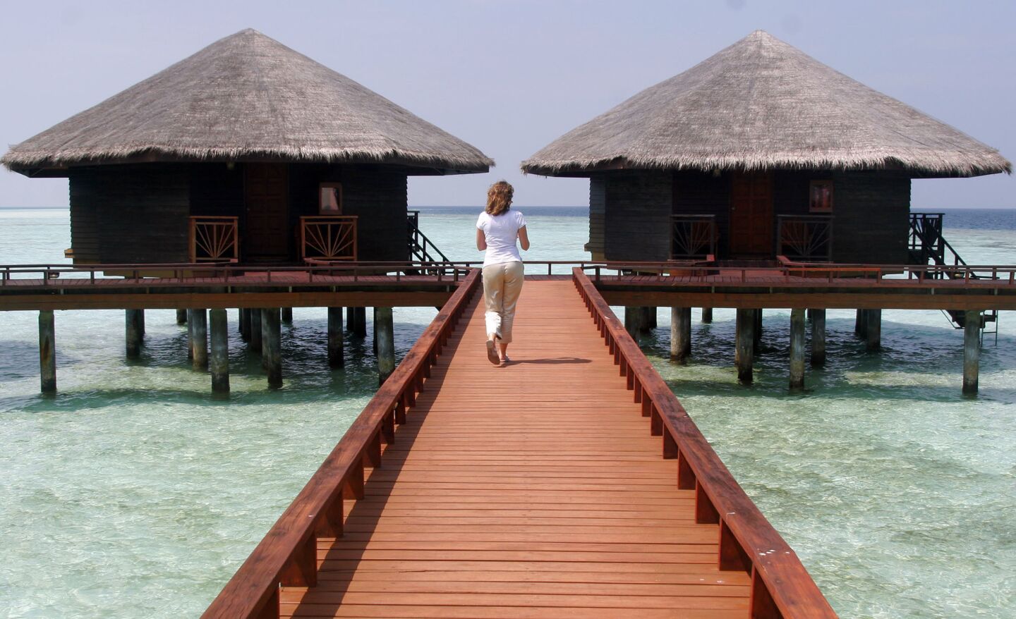 ** FILE ** A resort employee walks along the deserted walkway of the Baros Island resort, Jan. 15, 2005 in the Maldives. The Maldives economy, which depends in large part on tourism has taken a hit in the wake of the asian tsunami disaster, but many resort owners are hopeful that the industry will recover quickly as the resorts remained largely undamaged by the tsunami.(AP Photo/Ed Wray)