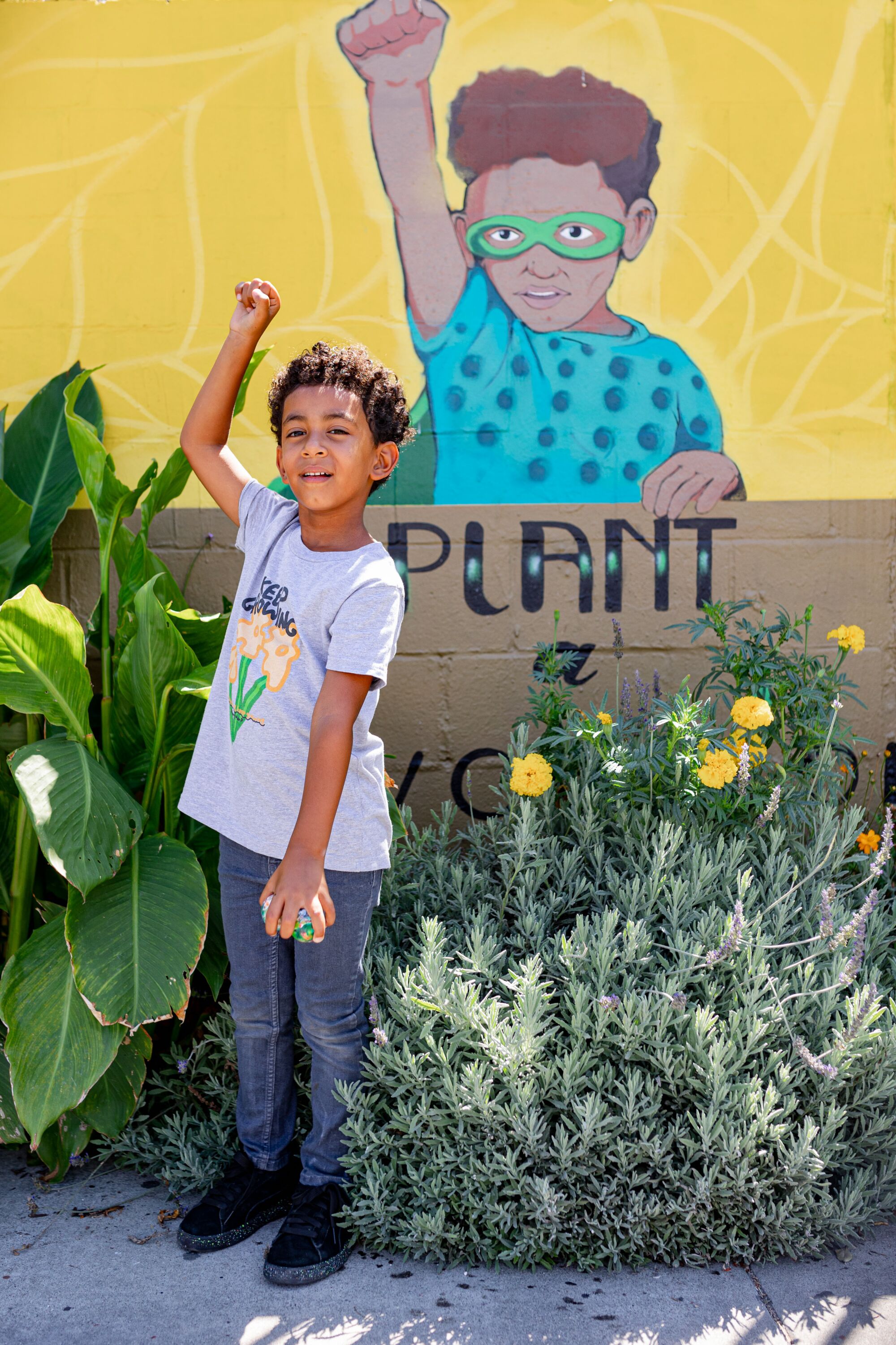 Alem Adis, 5, stands in front of a mural of him. 