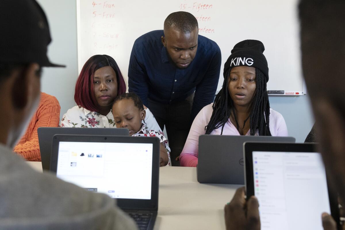 Huguens Altidor, en el centro, enseña informática a familias migrantes