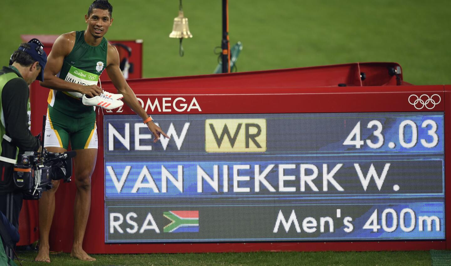 El sudafricano Wayde Van Niekerk festeja al lado del reloj con su tiempo récord en los 400 metros en los Juegos Olímpicos de Río 2016.