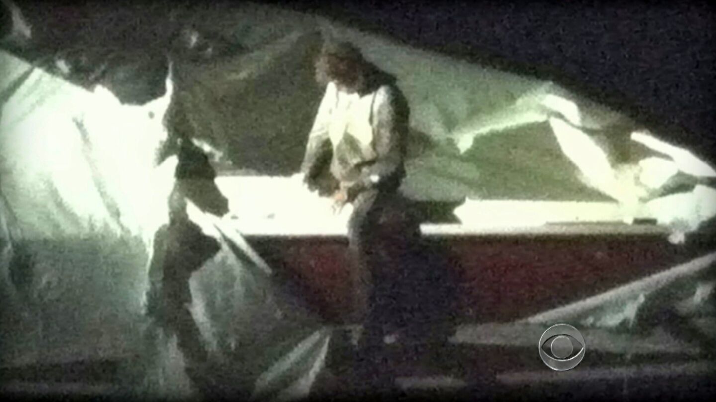 A television image shows Dzhokhar Tsarnaev, a suspect in the Boston Marathon bombing, straddling the side of the boat where he was found hiding Friday in Watertown, Mass.