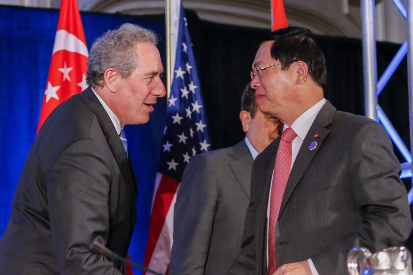 United States Trade Representative Michael Froman greets Vietnam Minister of Industry and Trade Vu Huy Hoang after the twelve Trans-Pacific Partnership member countries met in Atlanta, Georgia on Oct. 5.