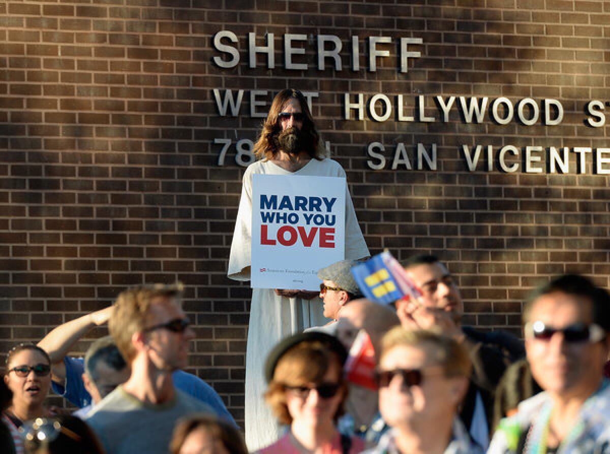 Kevin Lee Light, known as "West Hollywood Jesus," holds a sign celebrating the U.S. Supreme Court's Proposition 8 ruling during a community rally last week in West Hollywood.