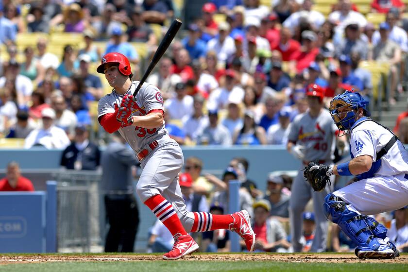 St. Louis Cardinals' Pete Kozma, left, hits a three-run double against the Dodgers.