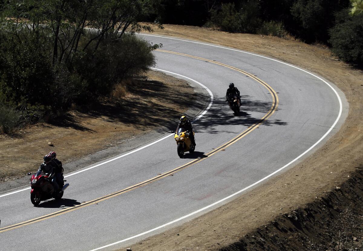Motorcyclists ride along Mulholland Highway.