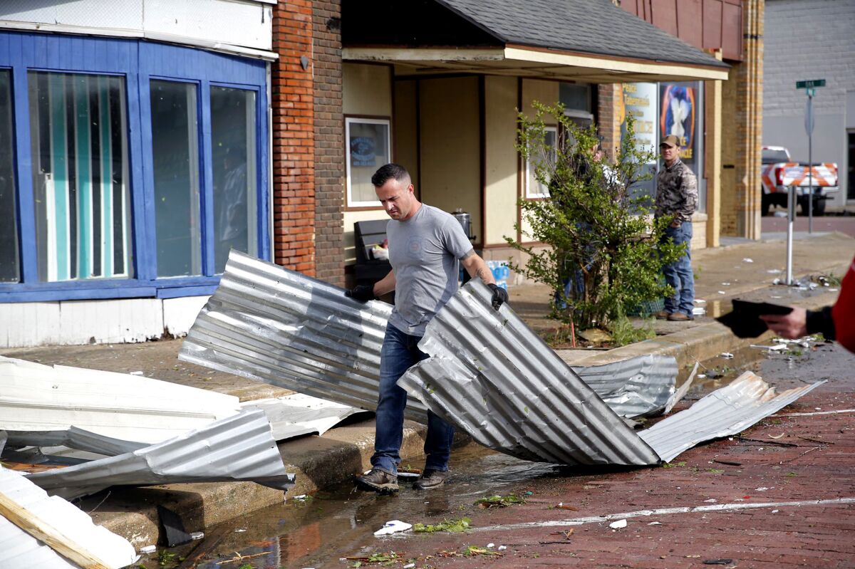 Tony Dowdy, of Victory Family Church, helps clean up tornado damage in Seminole, Okla. on Thursday, May, 5, 2022. A springtime storm system spawned several tornadoes that whipped through areas of Texas and Oklahoma, causing damage to a school, a marijuana farm and other structures. (Sarah Phipps/The Oklahoman via AP)