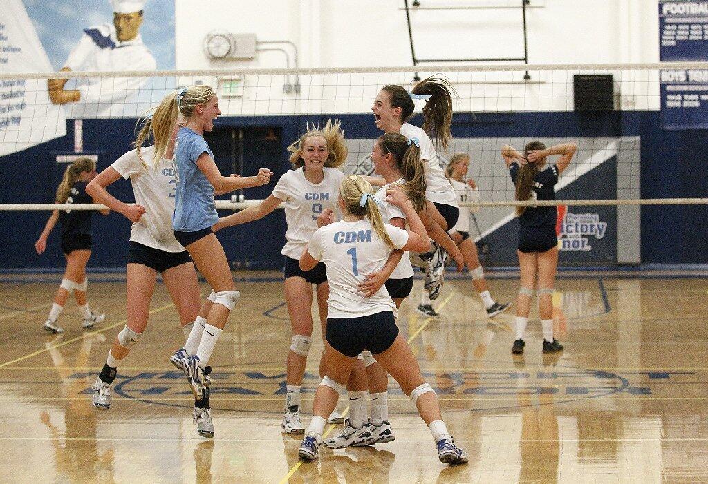 Corona del Mar High celebrates beating Newport Harbor 18-16 in the fifth set during the Battle of the Bay girls' volleyball match on Saturday.